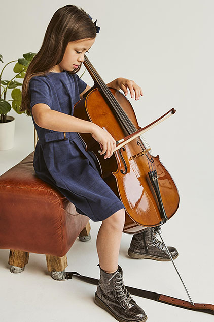 Niña aprendiendo violonchelo en casa
